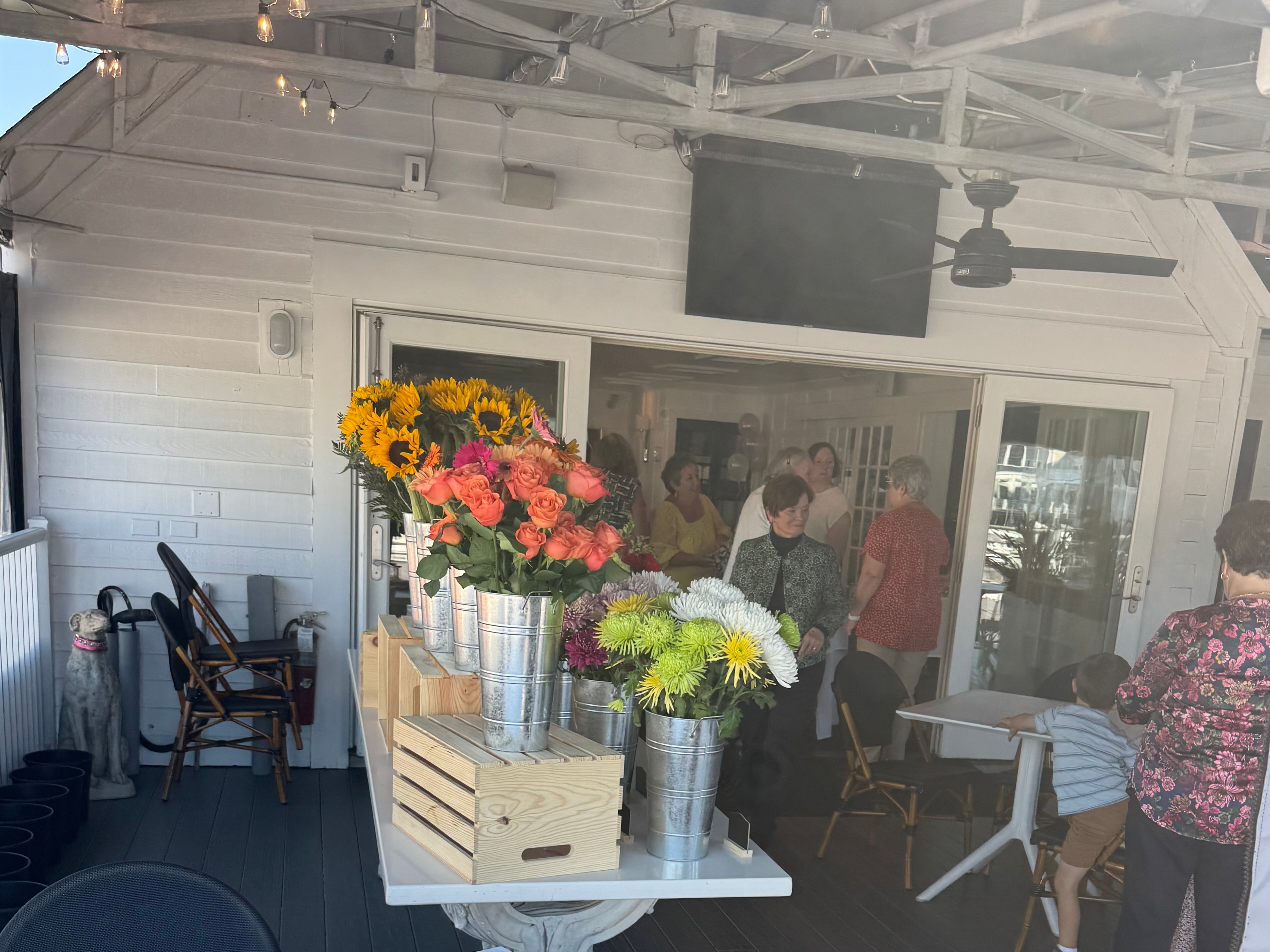 Colorful flowers in metal buckets and guests attending a DIY flower bouquet bar event