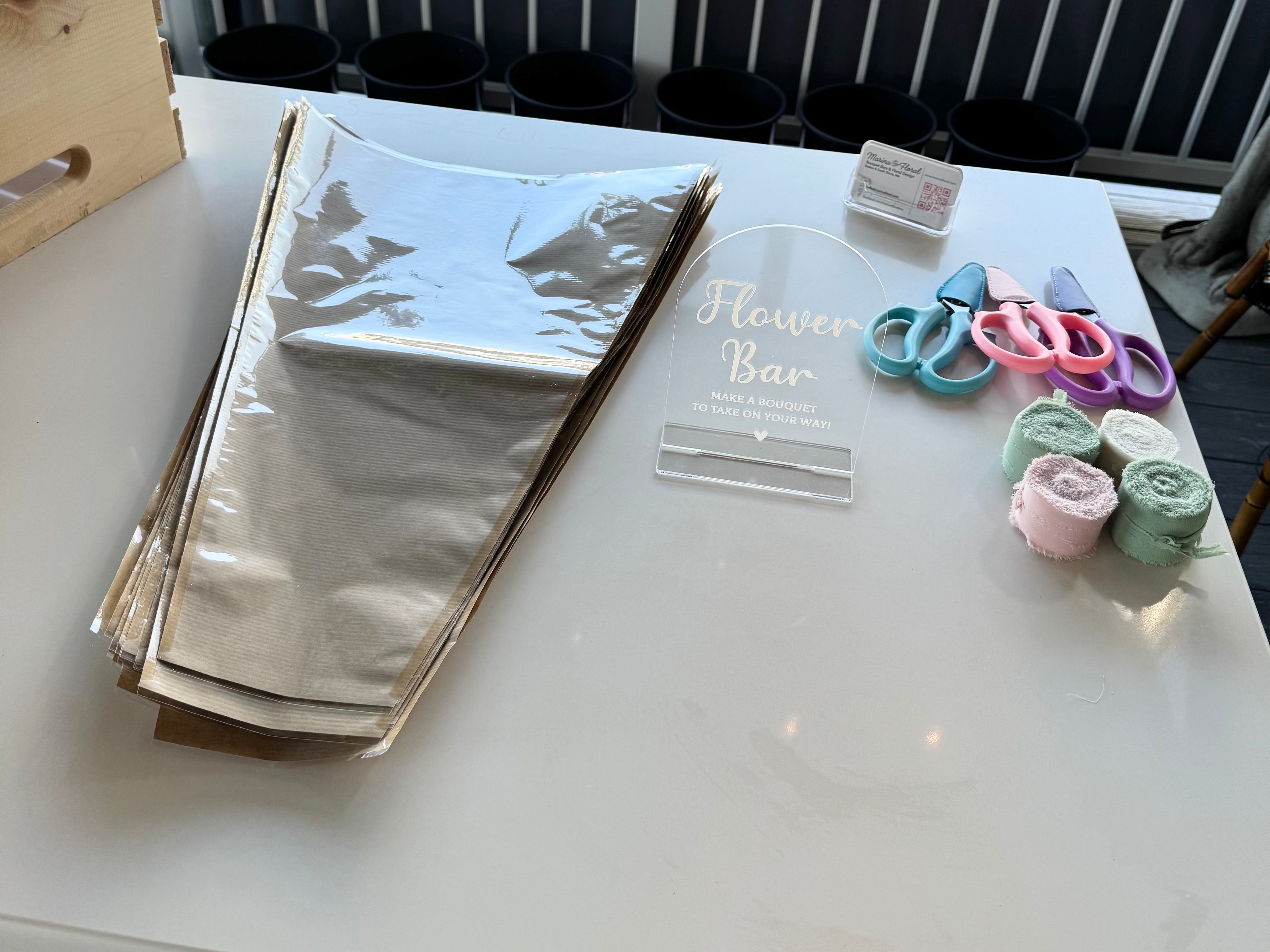 DIY flower bouquet bar materials for wrapping bouquets, including bouquet wraps, ribbons, signage, and scissors.